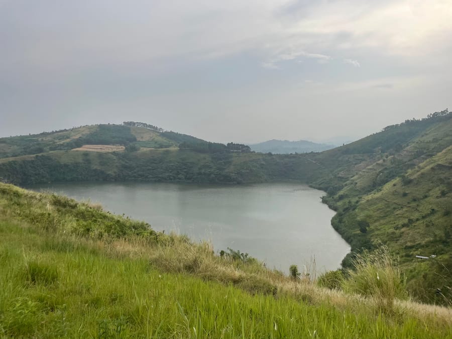 A crater lake held in a bowl of grass ridges, Fort Portal
