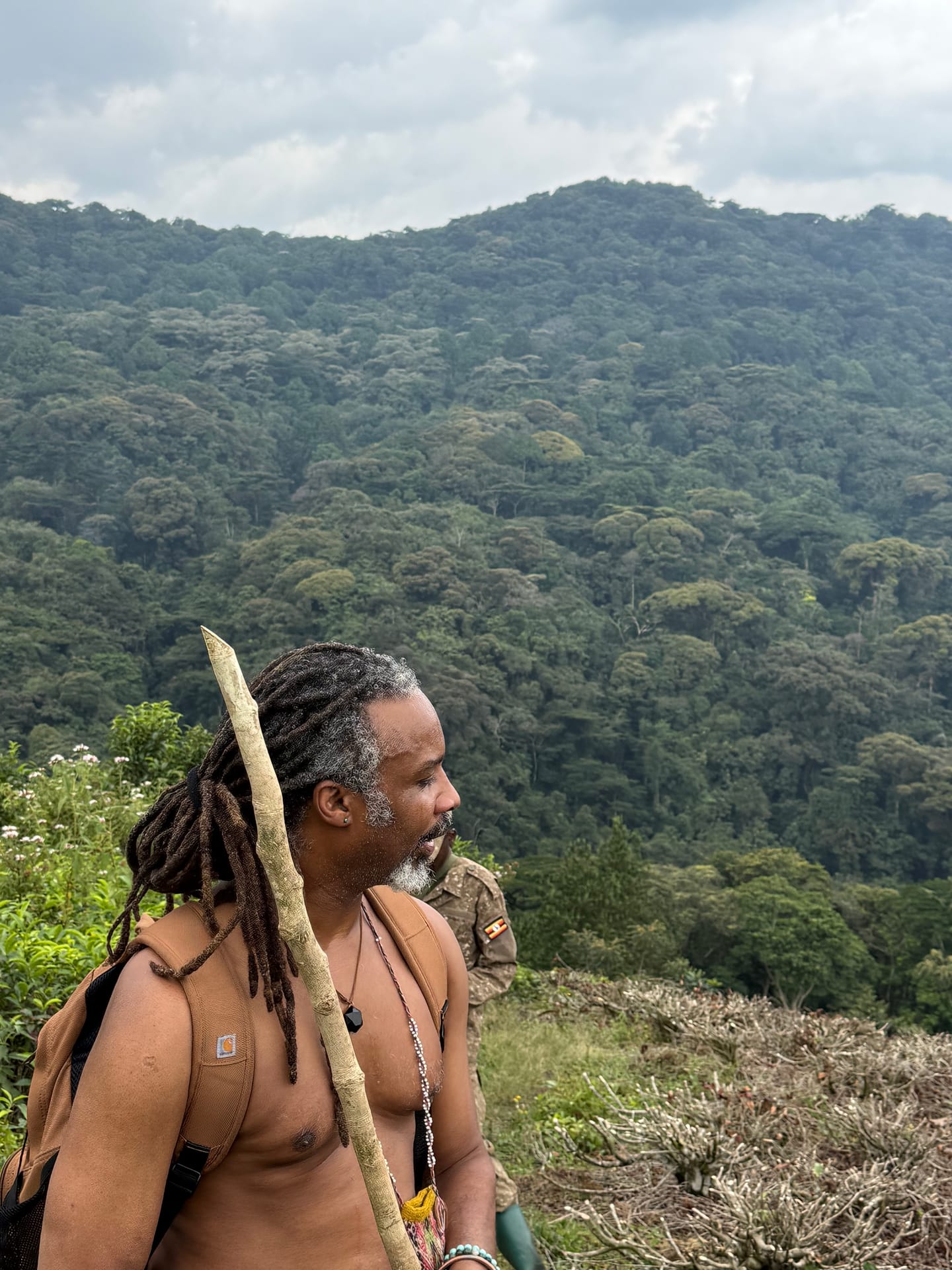 The trail into Bwindi Impenetrable Forest — Sacred Earth&rsquo;s founder and a Uganda Wildlife Authority ranger above the canopy.